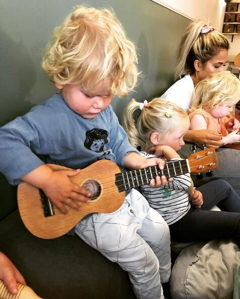 Kind speelt met gitaar tijdens muziekles op de dagopvang bij locatie Zo aan de Jan van Nassaustraat in Den Haag