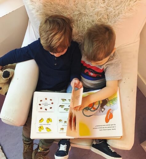 Kinderen lezen uit een boekje bij Zo aan de Jan van Nassaustraat