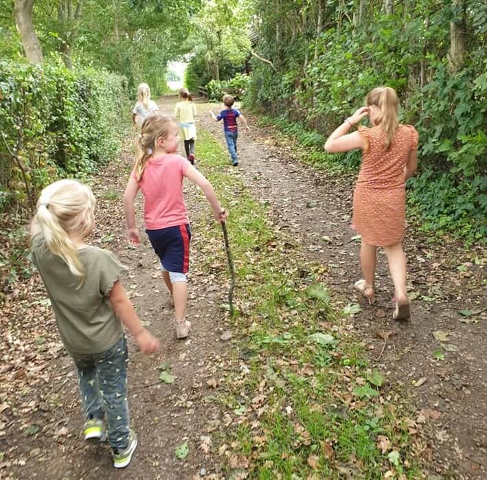 Kinderen lopen door het bos tijdens een uitje met de Outdoor BSO in Kruisland