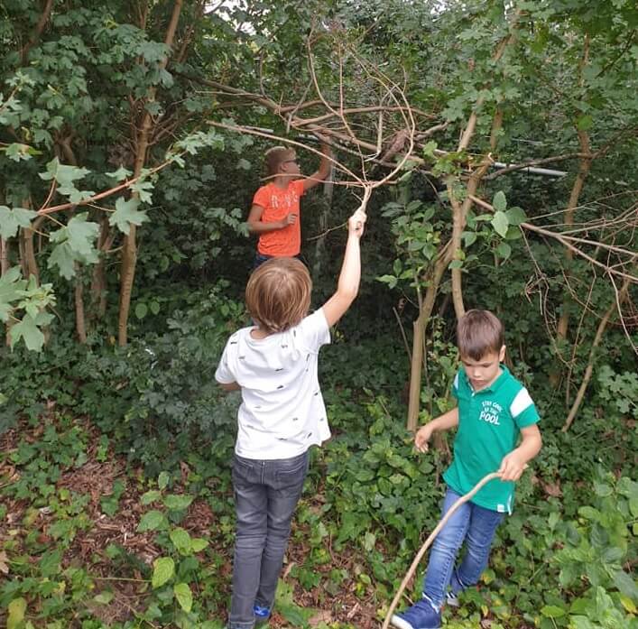 Kinderen spelen in het bos bij Outdoor BSO Kruisland