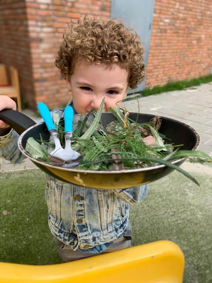 Kind speelt met pan met takjes
