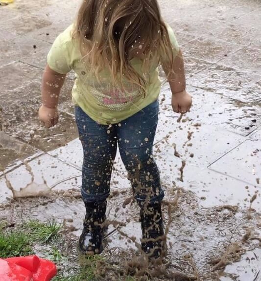 Meisje springt in een plas bij Zo aan de Westgroeneweg, kinderdagverblijf in Dinteloord