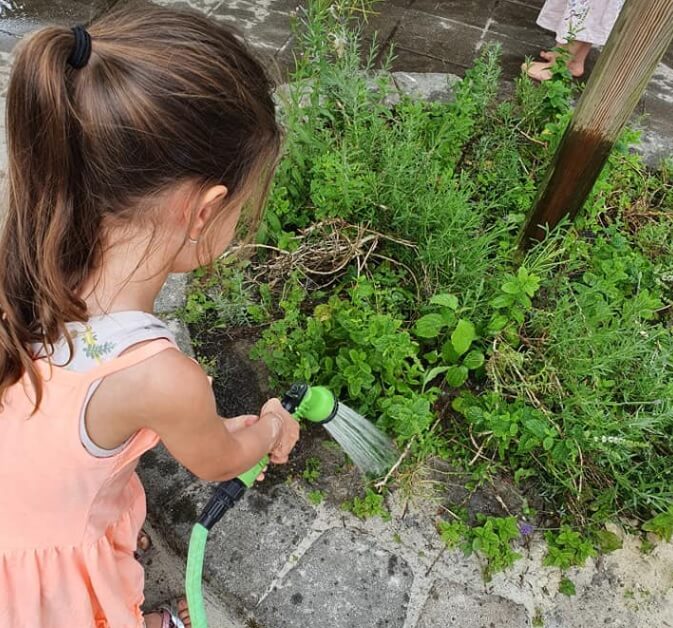 Meisje besproeit de tuin bij dagopvang Zo aan de Westgroeneweg