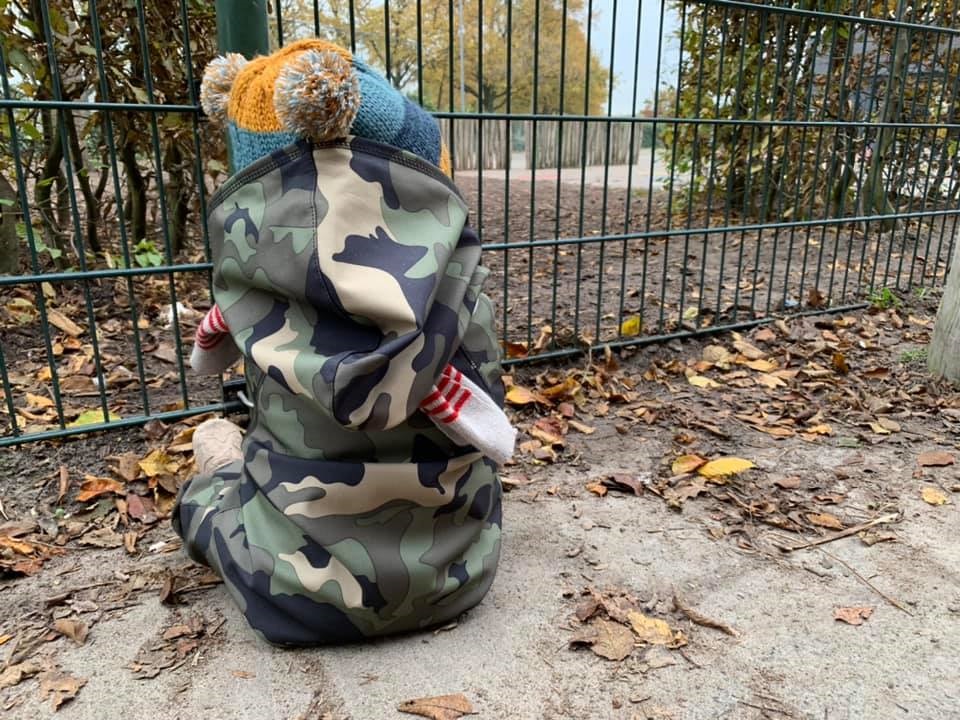 Kind zit buiten in buitenpakje