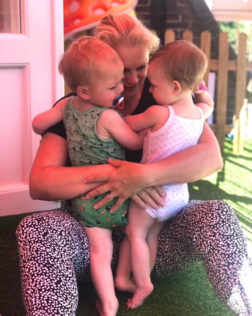 Pedagogisch medewerker knuffelt met baby's