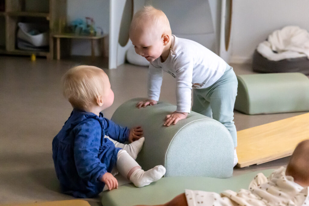 Twee kinderen op de dagopvang kijken lachend naar elkaar