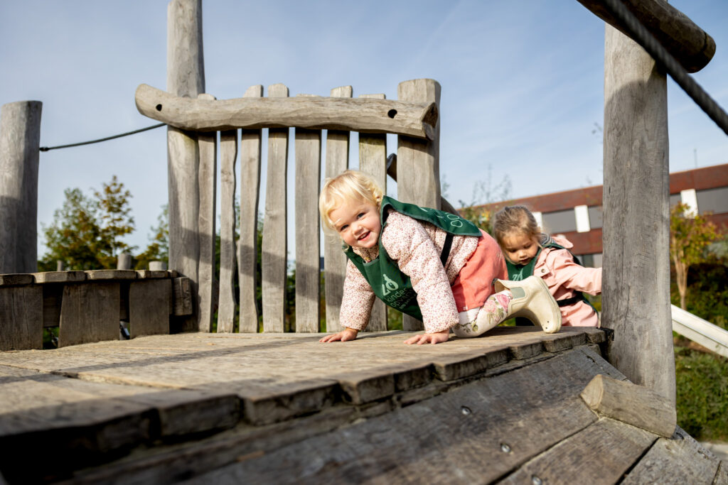 Peuters spelen buiten op het klimrek op de peuteropvang