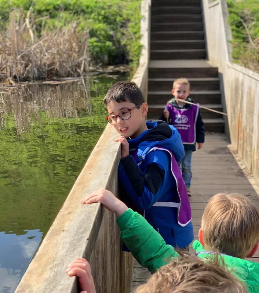 Kinderen staan op een brug tijdens een bso uitje van Zo op de Schans
