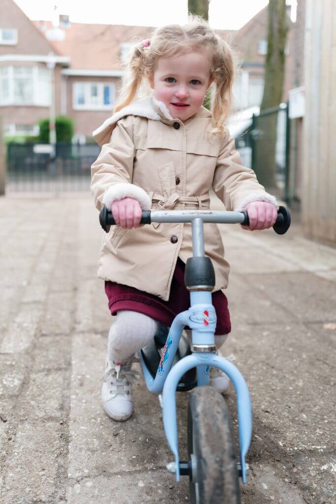 meisje met blond haar zit op blauwe step