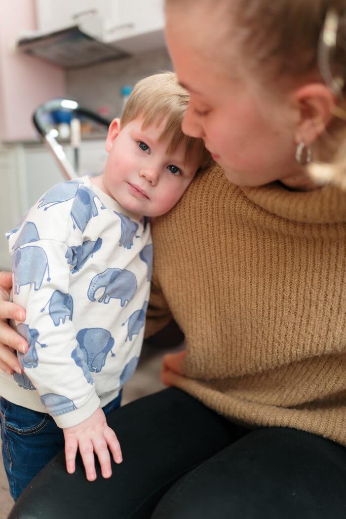 Kind knuffelt met een pedagogisch medewerker op de dagopvang
