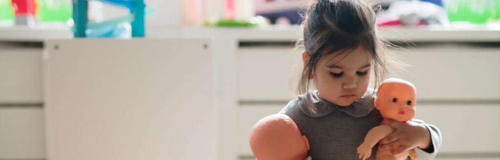 meisje houdt twee poppen vast