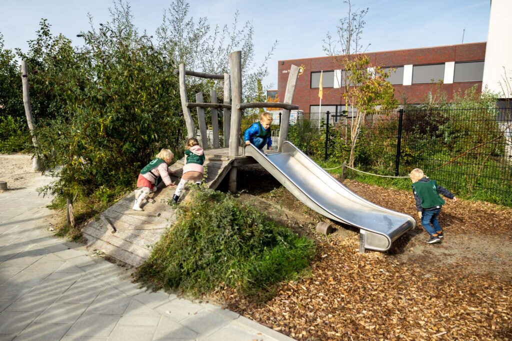 Kinderen spelen buiten bij de glijbaan bij vestiging Zo op Brede School Tholen