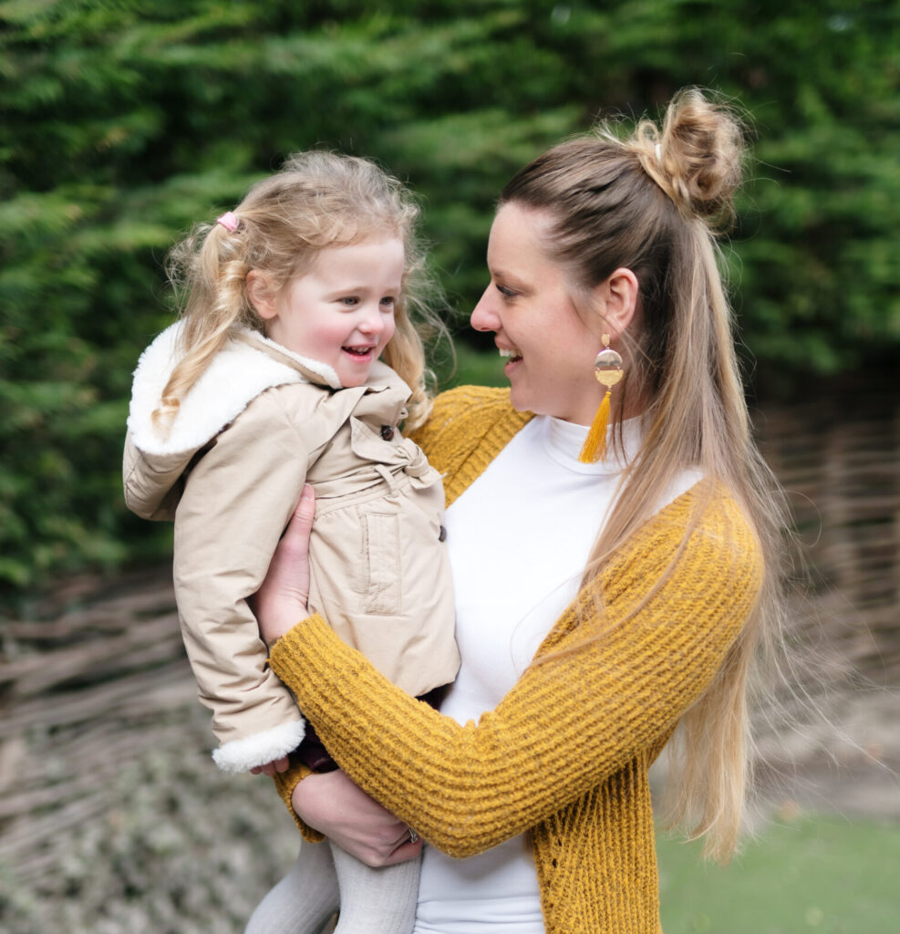 pedagogisch medewerker houdt klein meisje vast