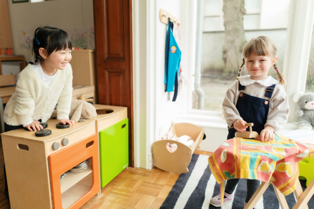 Twee kinderen spelen in de speelkeuken op de internationale kinderopvang