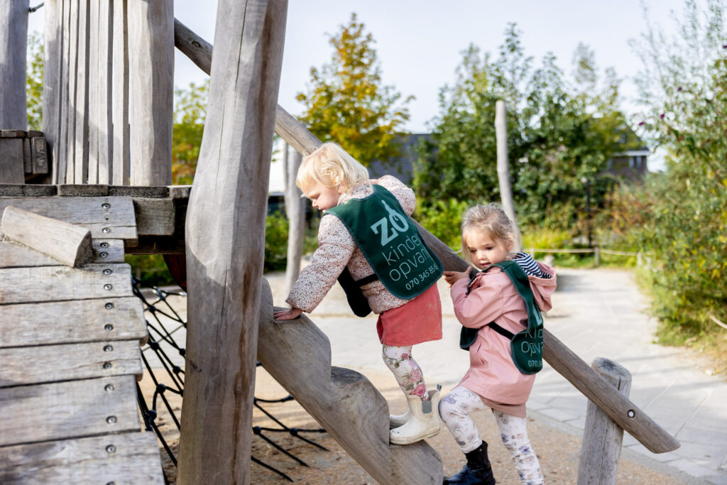 Twee kinderen klimmen in het klimhuisje in de speeltuin bij de dagopvang