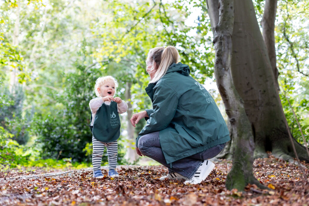 Medewerker Zo Kinderopvang en kind spelen in het bos