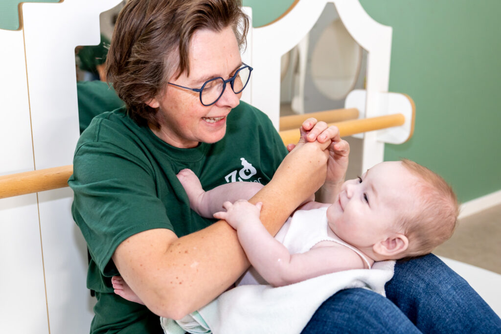 Pedagogisch medewerker van Zo Kinderopvang speelt met een baby