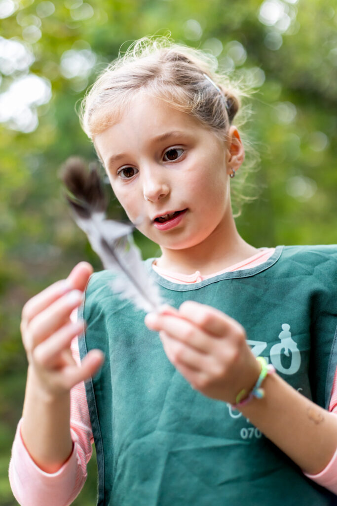 BSO meisje van Zo Kinderopvang bestudeert een veer