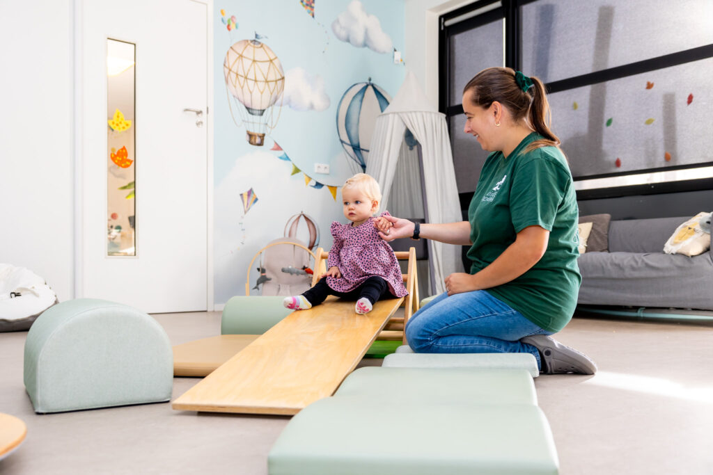 Pedagogisch medewerker speelt ontwikkelingsgericht met een kind op de dagopvang