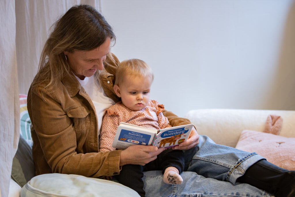 Pedagogisch medewerker leest voor aan een kind